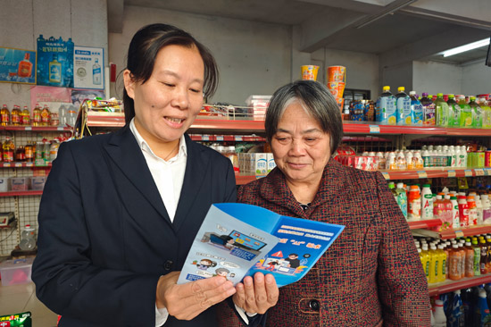 城区局（营销部）客户经理向银发客户宣传“AI”骗术防诈知识3。徐港（摄）