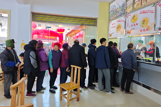 老人们排队领取爱心米粉就餐