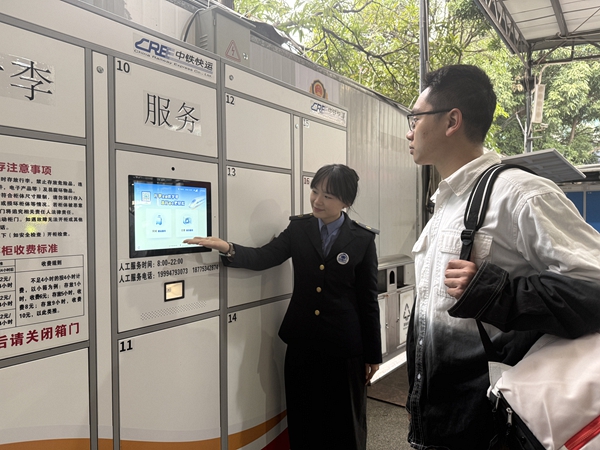 在南宁车站出站口处，工作人员引导旅客使用“轻装行”服务。汪璐璐摄