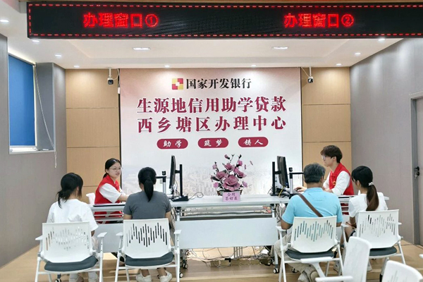 西乡塘区学生资助服务中心工作人员正在给办理助学贷款的学生签订合同。