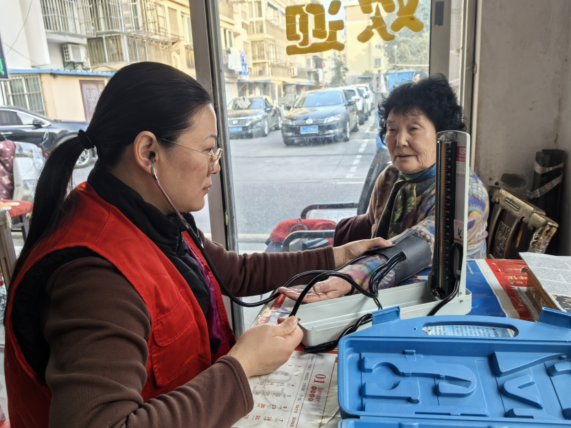 志愿者为社区老人测量血压。