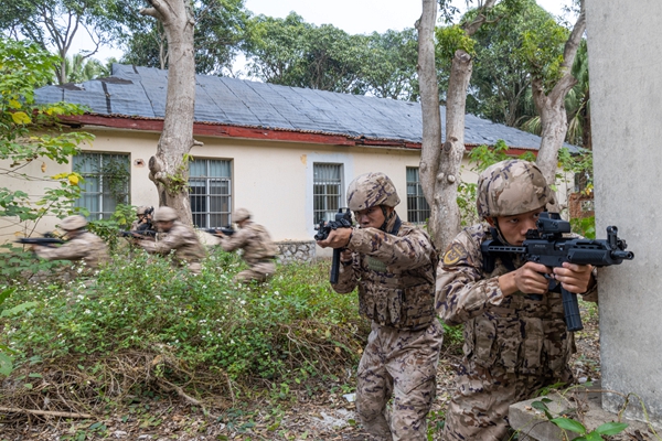 武警官兵在进行小组协同搜索。