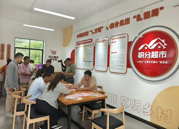 中國電信柳江分公司與三都鎮黨委政府協同，通過“數字鄉村+積分超市”模式，推動鄉村治理現代化，培育文明鄉風。圖為電信工作人員現場指導村民使用平台