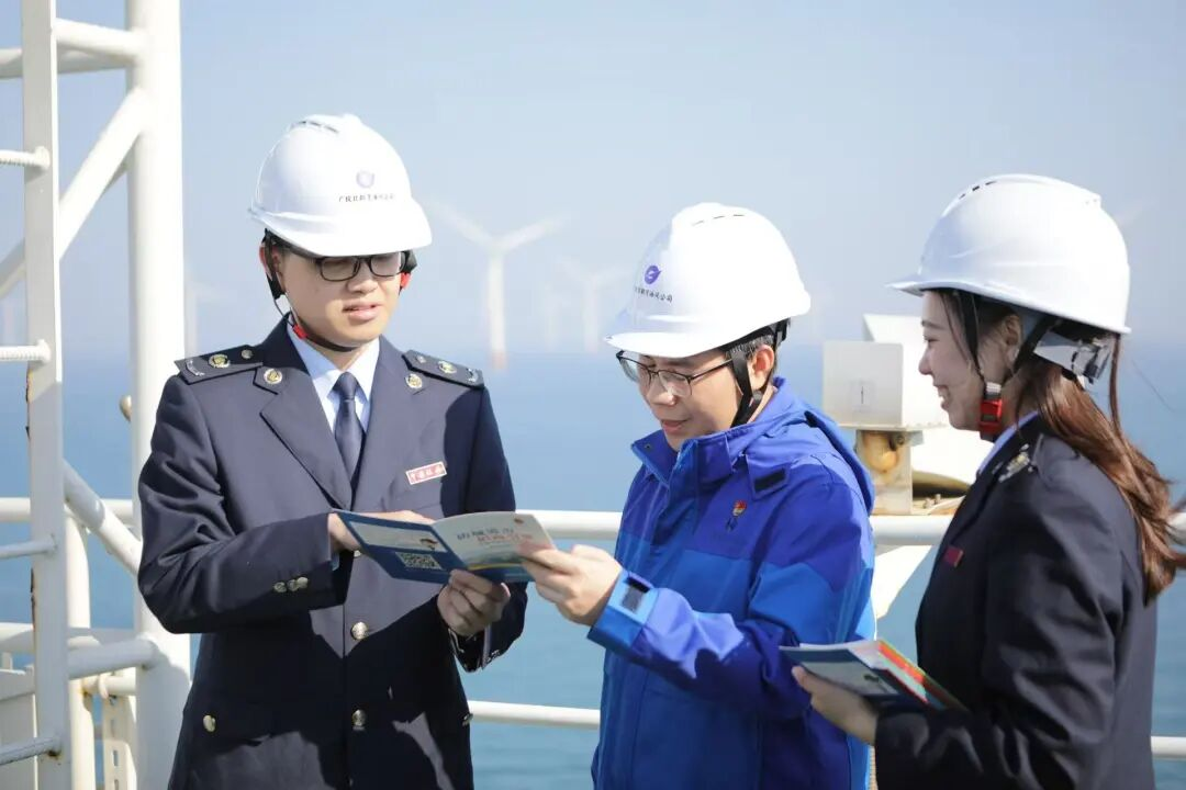 图为防城港市税务干部到防城港海上示范风电项目基地，了解企业运营情况，辅导最新的税收优惠政策。