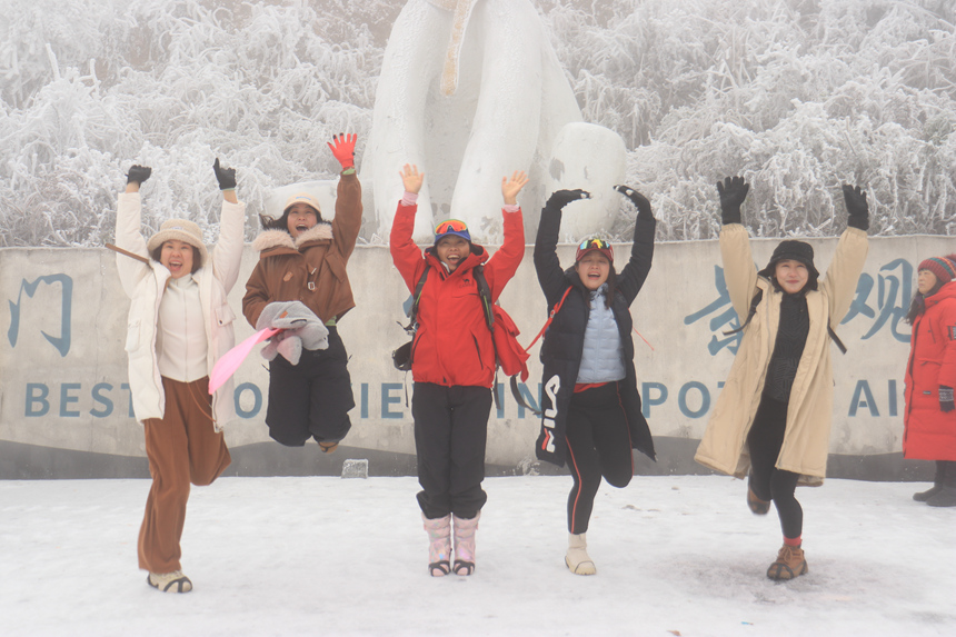 游客在隘门界雪景公园打卡点处合影留念。