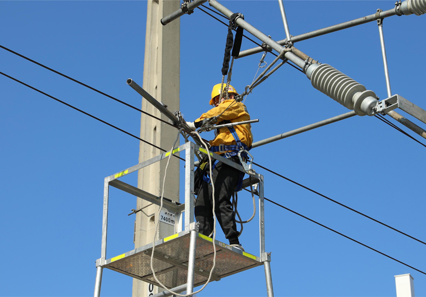 接触网工在更换定位装置。钟文君摄