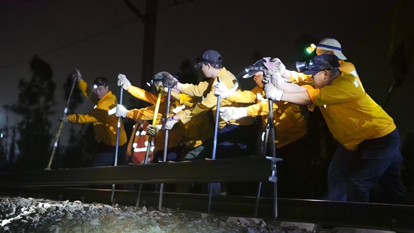 職工齊心協力將舊鋼軌移出。陳健攝