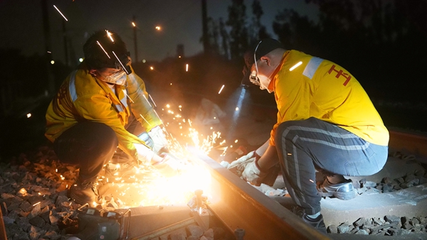 職工使用工機具打磨鋼軌。陳健攝