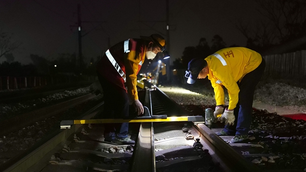 職工使用儀器測量鋼軌數據。陳健攝