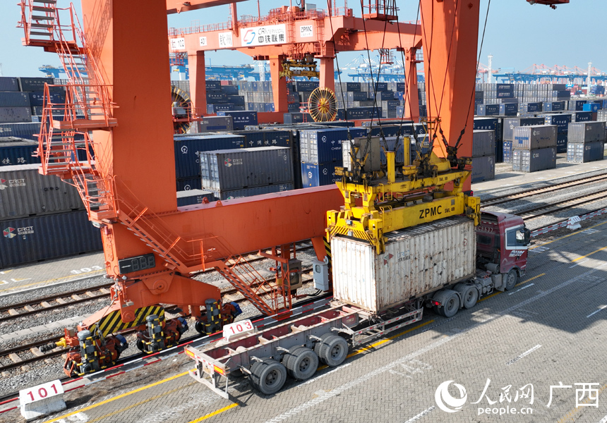 广西钦州铁路集装箱中心站内,自动化龙门吊在吊装集装箱货物。人民网记者 王勇摄
