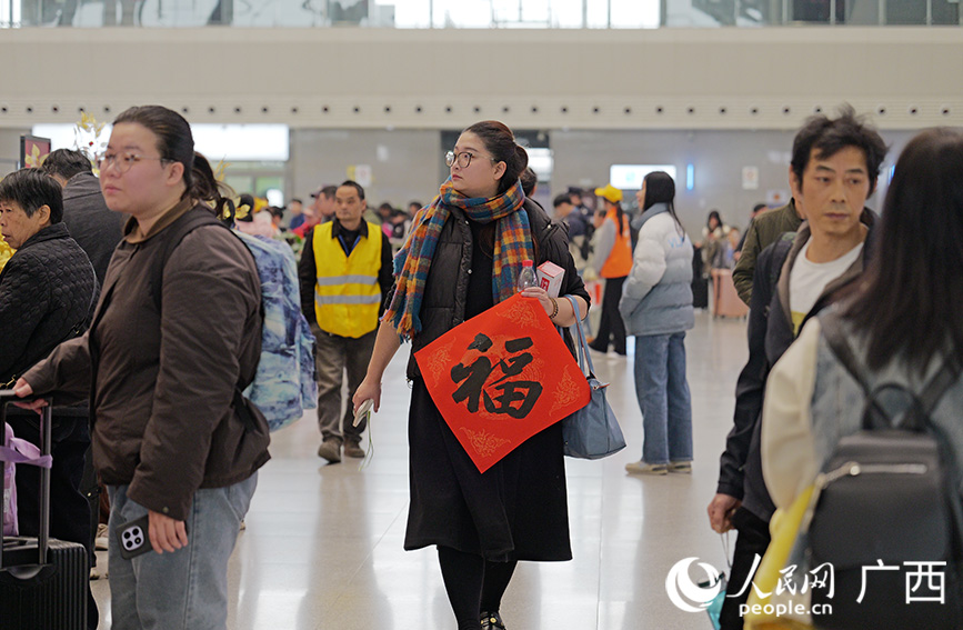 旅客领取春联。人民网 梁章晖摄