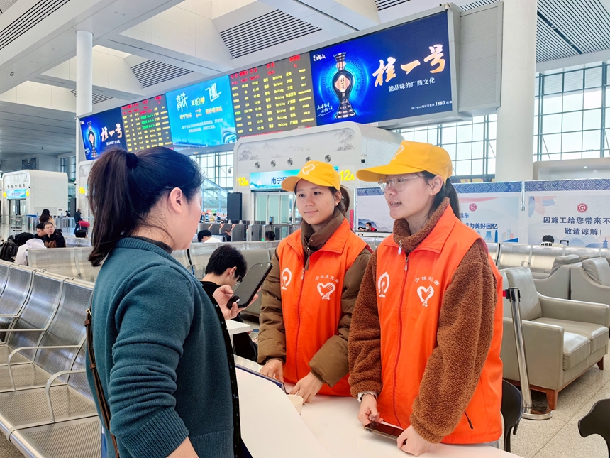 南宁东站志愿者回答旅客咨询。秦蓉蓉摄