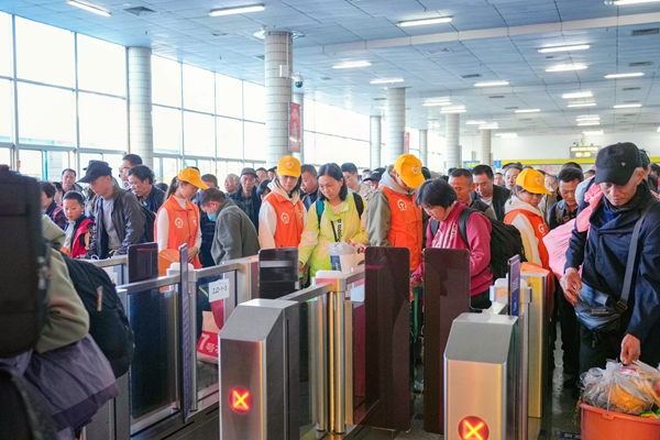 湛江站志愿者引导旅客有序进站乘车。李超宇摄