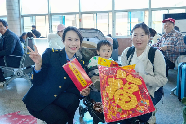 工作人员开心为旅客送“福”。李超宇摄
