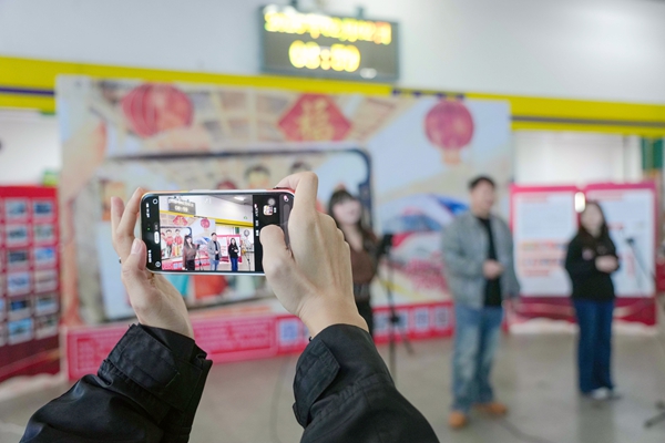 旅客用手机记录快闪活动瞬间。李超宇摄