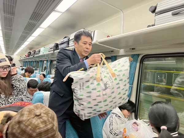 列车员正在帮旅客整理行李。吴飞摄