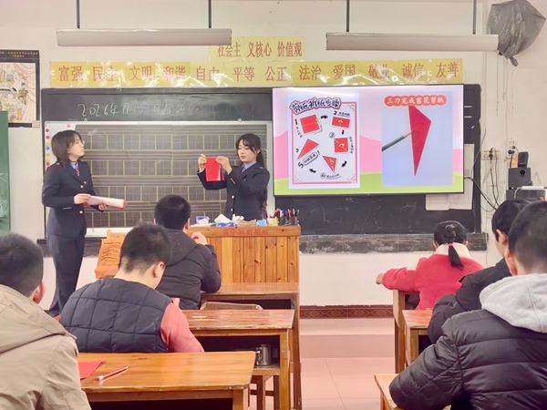 青年志願者正在引導孩子們進行剪紙。鐘文君攝