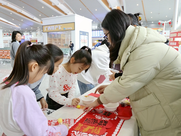 玉林市圖書館人員教小朋友旅客體驗“碼上拓福”。陳海嬋攝