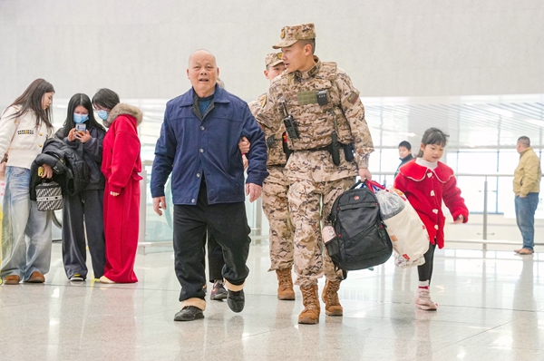 武警官兵協助老人搬運行李。賴治華攝