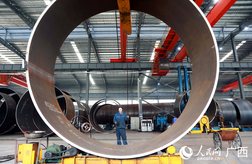 工人正在對風力發電塔筒設備進行吊裝作業。