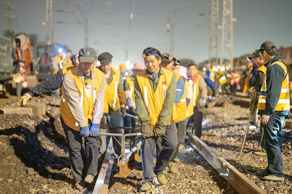 众人合力把钢轨抬走。黄舞杰摄