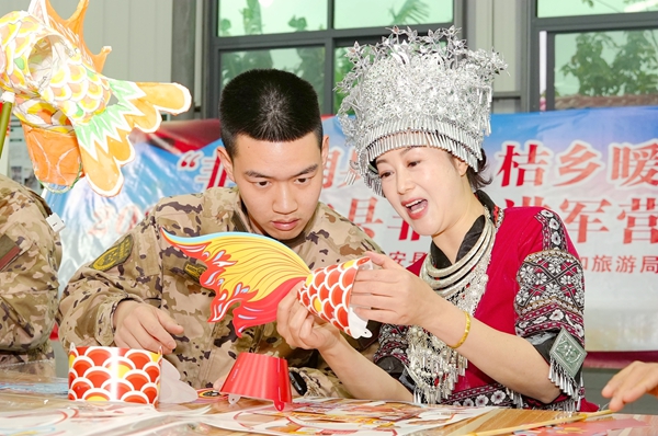 官兵與駐地群眾體驗非遺魚燈制作。賴治華攝