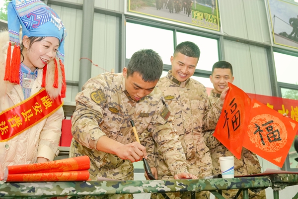 官兵與駐地群眾一起寫新春福字。賴治華攝