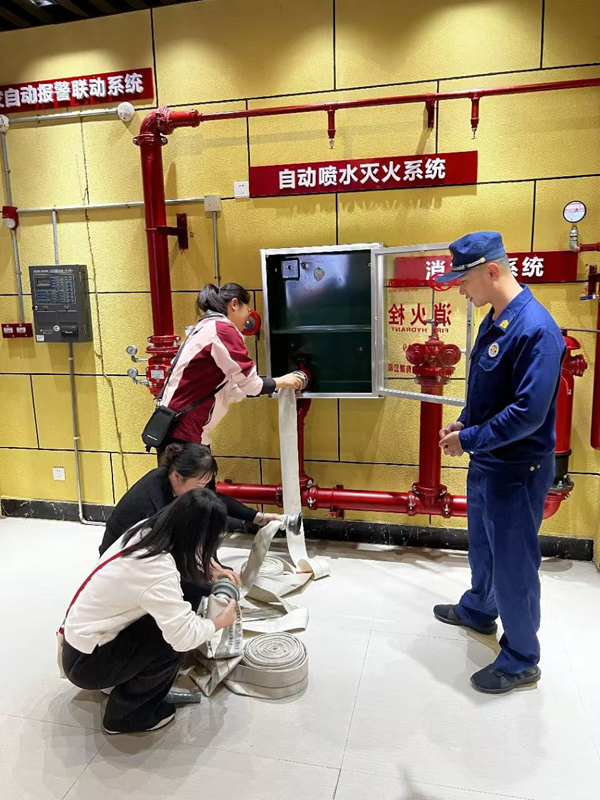大新烟草员工在消防科普体验馆模拟使用自动喷水灭火设施。农娟摄