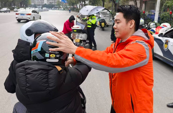 平安产险广西分公司工作人员为出行市民戴上安全帽，为推动良好出行环境建设贡献平安力量。平安产险广西分公司供图