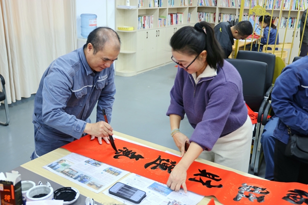 书法爱好者写春联。许裕摄