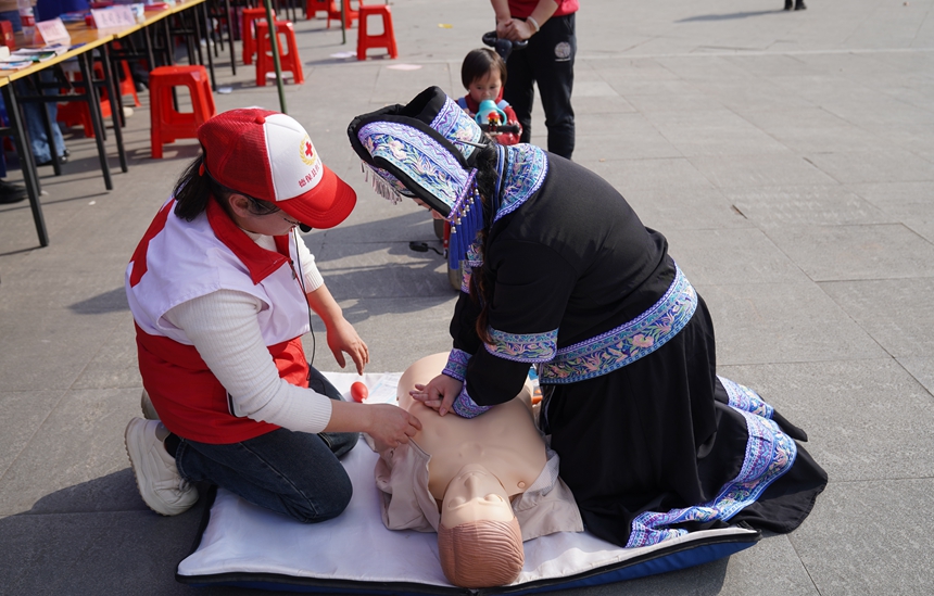 群众在活动现场学习急救技能。黄丽电摄