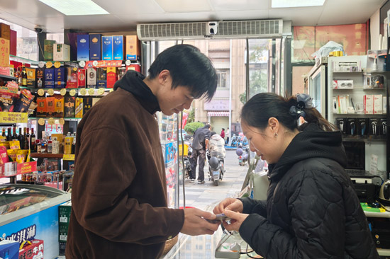 零售户为进店游客提供旅游行程规划服务 唐蕙芳摄