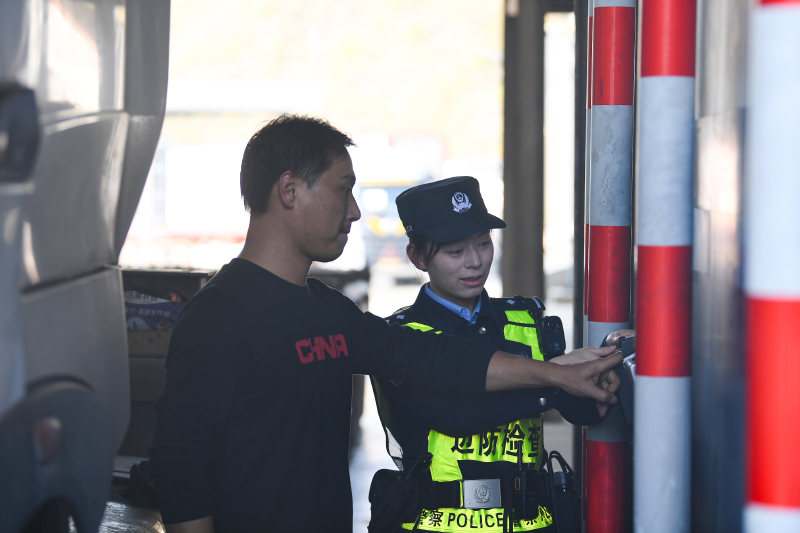 廣西邊檢總站移民管理警察引導貨車司機使用快捷通關系統。博林攝