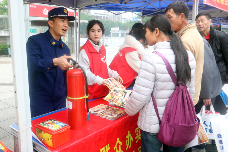 消防员手把手指导群众操作灭火器。罗帮勇摄