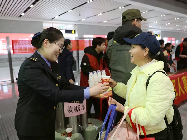 圖為南寧東站工作人員為返鄉專列旅客送上姜糖水。麥竹嫻攝