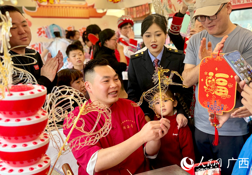 非遺代表性傳承人在Z6次列車上做糖畫，營造濃厚的過年氛圍。