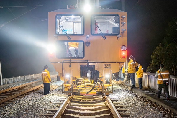女子大機組成員在車上車下配合作業。李勇攝