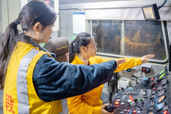 司機楊瑤和副司機覃倩正在駕駛大型養路機械。李勇攝