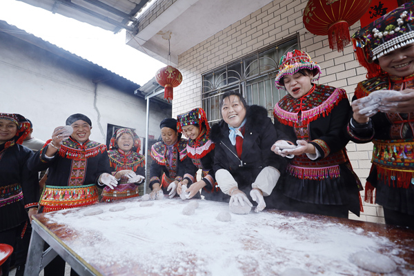 瑶族阿姐们正把刚打好的糯米搓成糍粑。