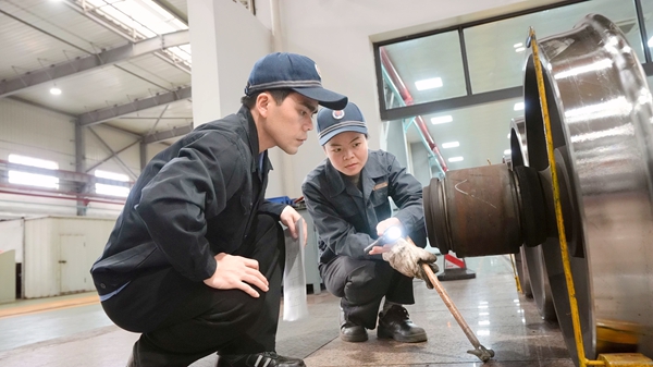 李業和黎天晴在核對輪對檢修質量。覃園介攝