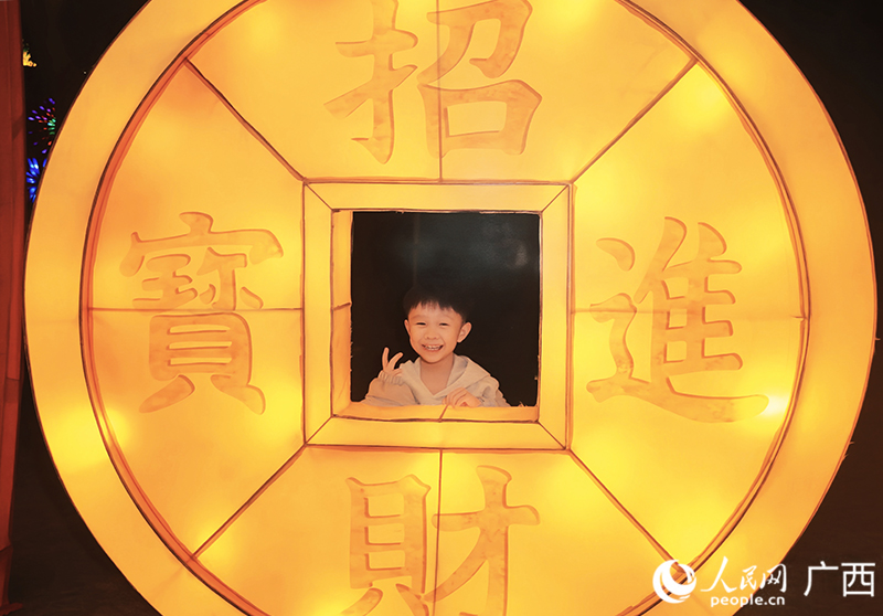 孩子在“錢程似錦”長廊拍照打卡。人民網 韋歡攝