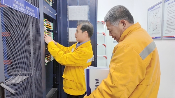 吳鐘(右)與許昆箭(左)在核對設備業務台賬。羅薇攝