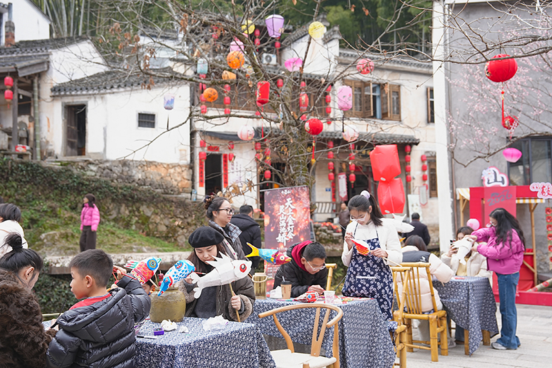 游客在灵山水街体验鱼灯制作。
