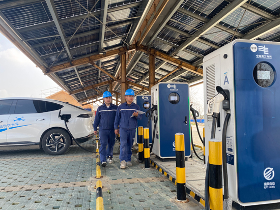 在南方电网广西南宁市宾阳县古辣镇稻花香里综合能源站，巡检人员检查充电设施运行情况。陈凤彪摄