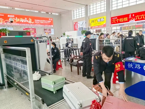 桂平站工作人員協助旅客安檢進站。張留軍攝