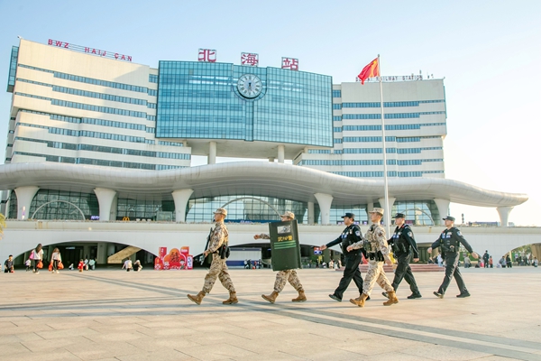 武警官兵与公安干警在高铁站进行联勤巡逻。