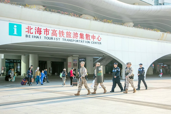 武警官兵与公安干警在高铁站进行联勤巡逻。