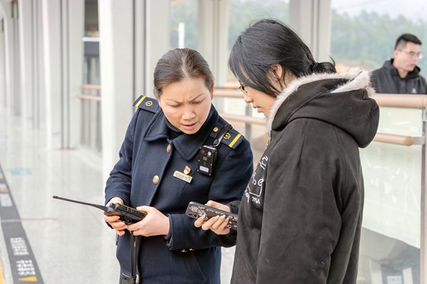 林东在站台解答旅客的问题。兰炳侣摄