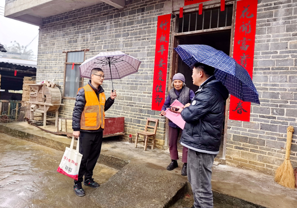“就業導游”冒雨進村入戶介紹企業用工信息。