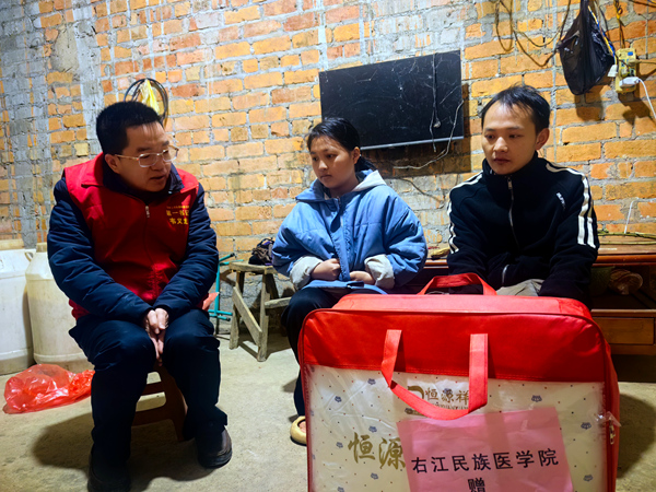 第一书记韦义龙入户慰问赠送右江民族医学院慰问品。黄国府摄
